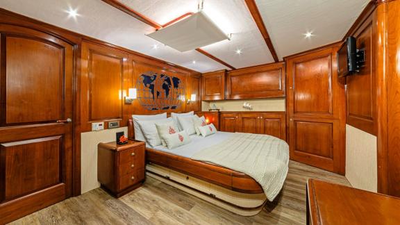 Luxurious cabin with wood panelling, large bed and stylish lighting.